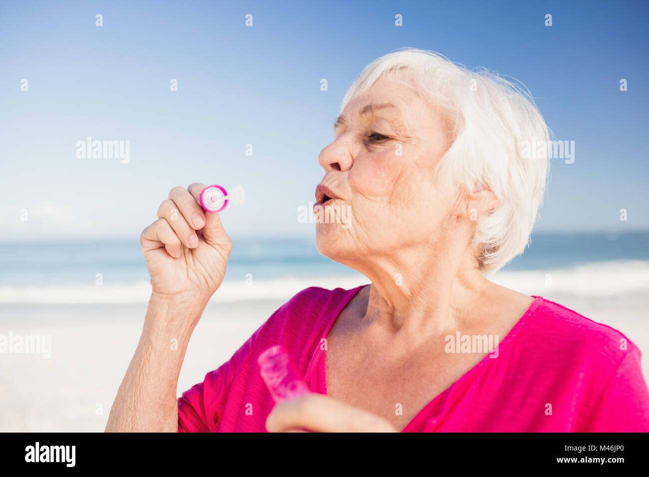 Ältere Frau machen Bläschen mit einer Blase wand Stockfoto