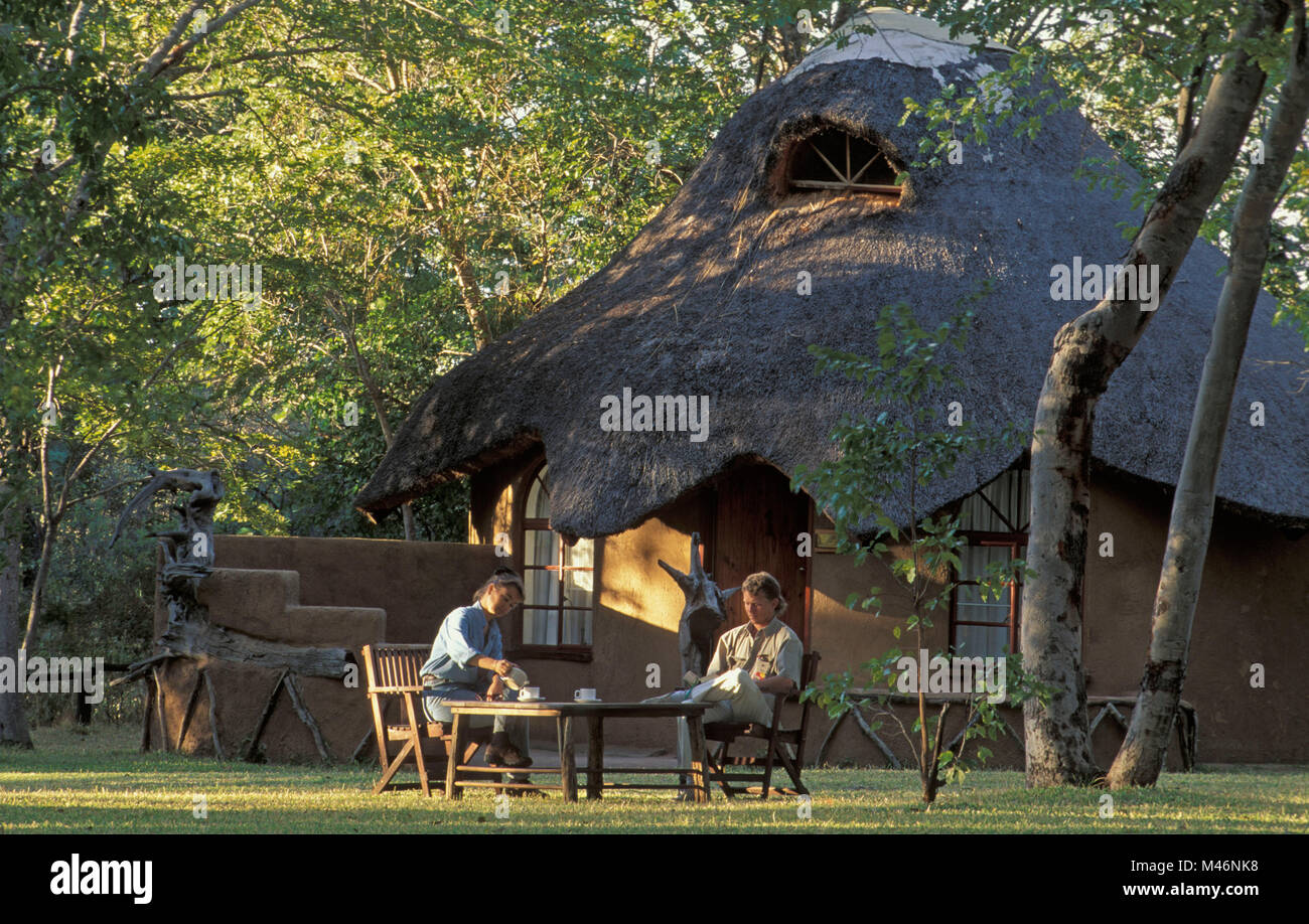 Simbabwe. Hwange National Park. Touristen. Sable Valley Lodge. Mann und Frau in Tee. Stockfoto