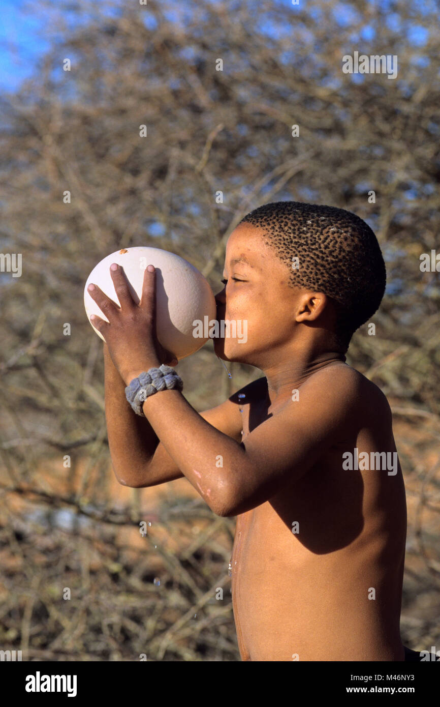 Namibia. Kalahari Wüste in der Nähe von Keetmanshoop. Bushman mit straussenei als waterbottle. Junge. Stockfoto