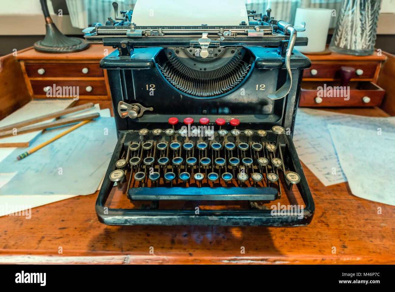 Antike, Schreibmaschine mit ein Blatt weißes Papier und Metall Kompass steht auf einem braunen Holztisch Stockfoto