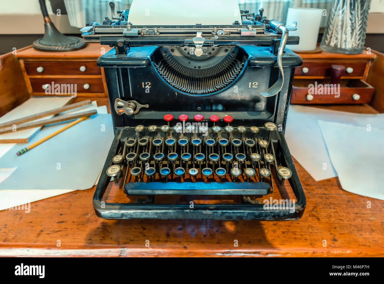 Antike, Schreibmaschine mit ein Blatt weißes Papier und Metall Kompass steht auf einem braunen Holztisch Stockfoto