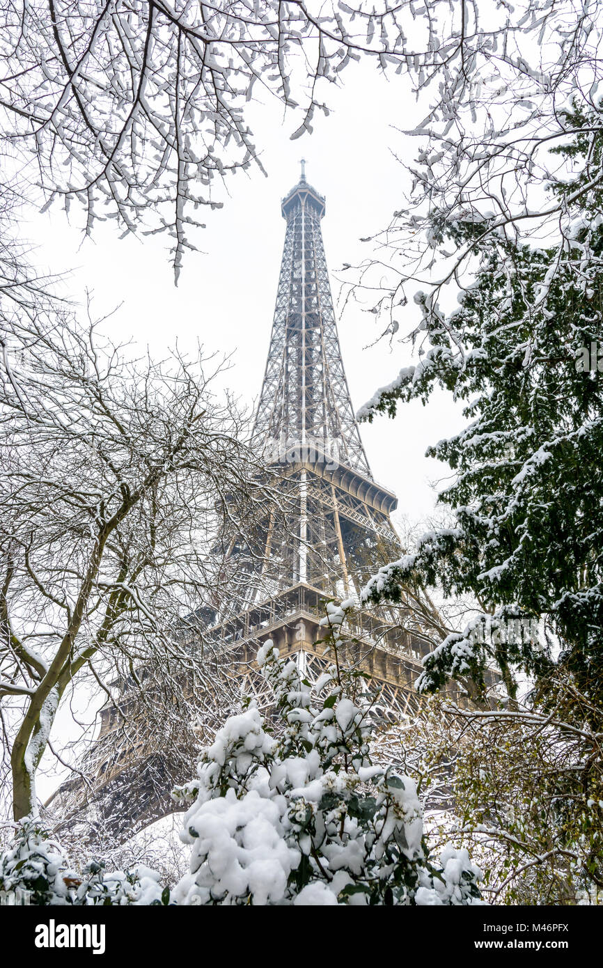 Winter in Paris im Schnee. Low Angle Blick auf den Eiffelturm durch schneebedeckten Ästen. Stockfoto