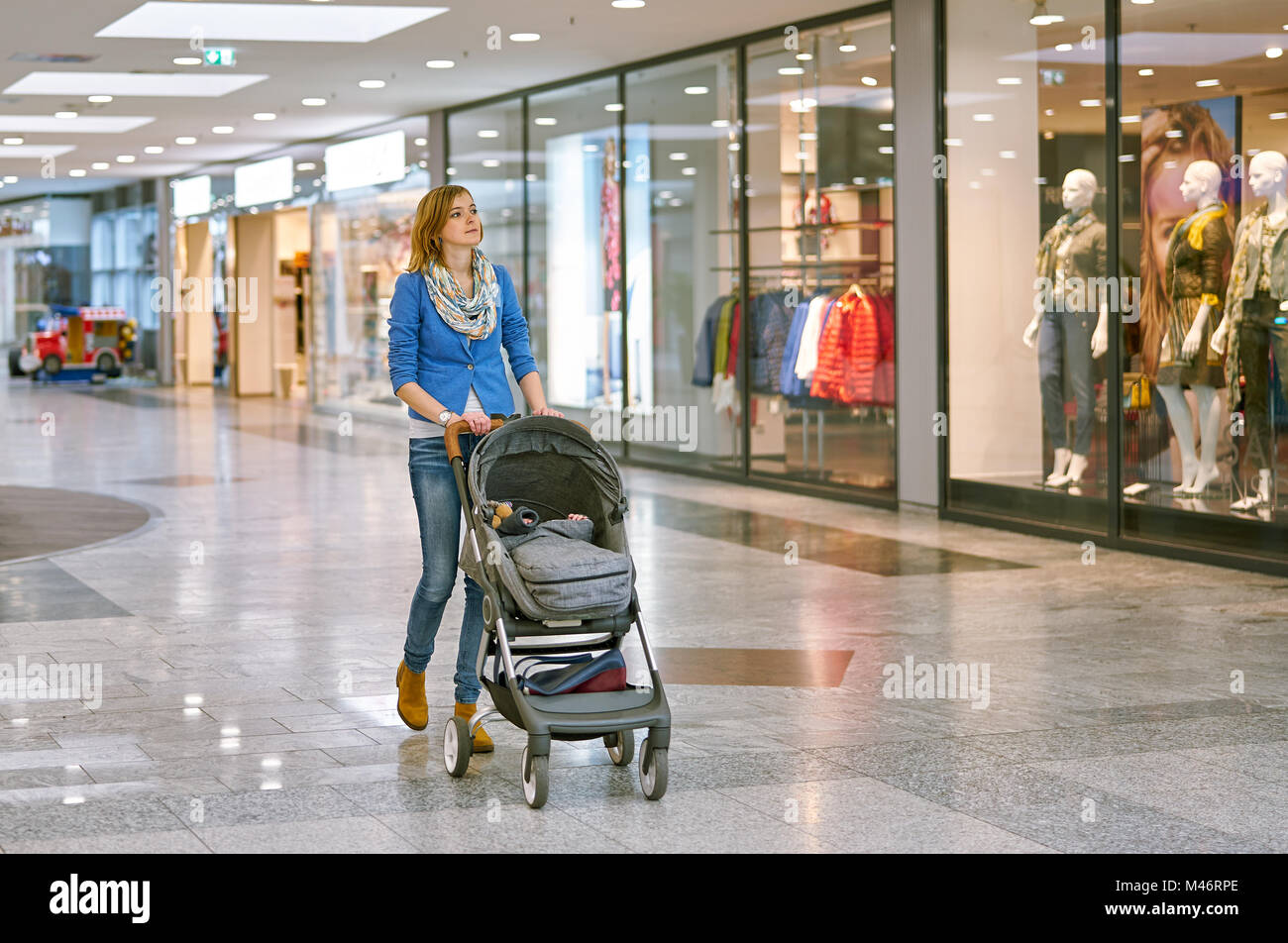 Junge Frau mit Baby während des Einkaufs Stockfoto