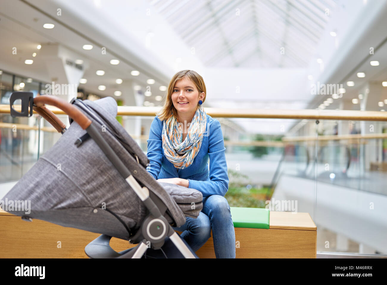 Junge Frau mit Baby im Einkaufszentrum Stockfoto