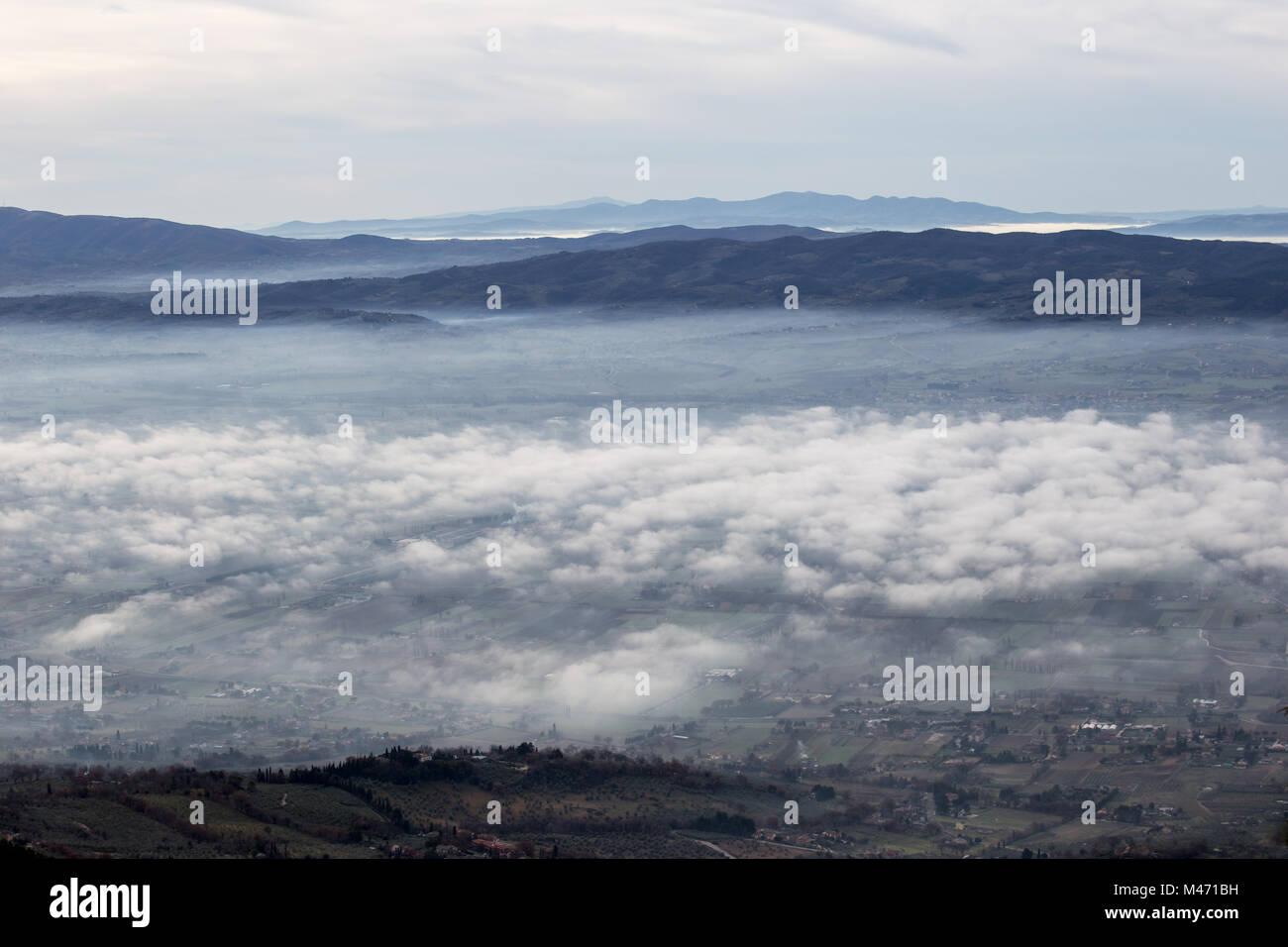 Schöne Aussicht von Umbrien Tal in einem Winter morgen, mit Nebel die Bäume und Häuser Stockfoto