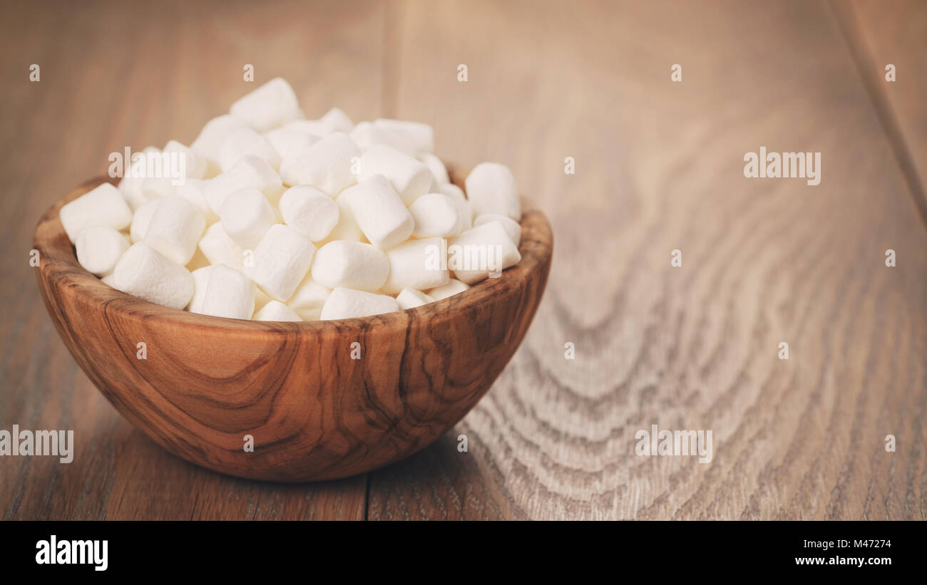 weiße Marshmallows in Holzschale auf Tisch Stockfoto