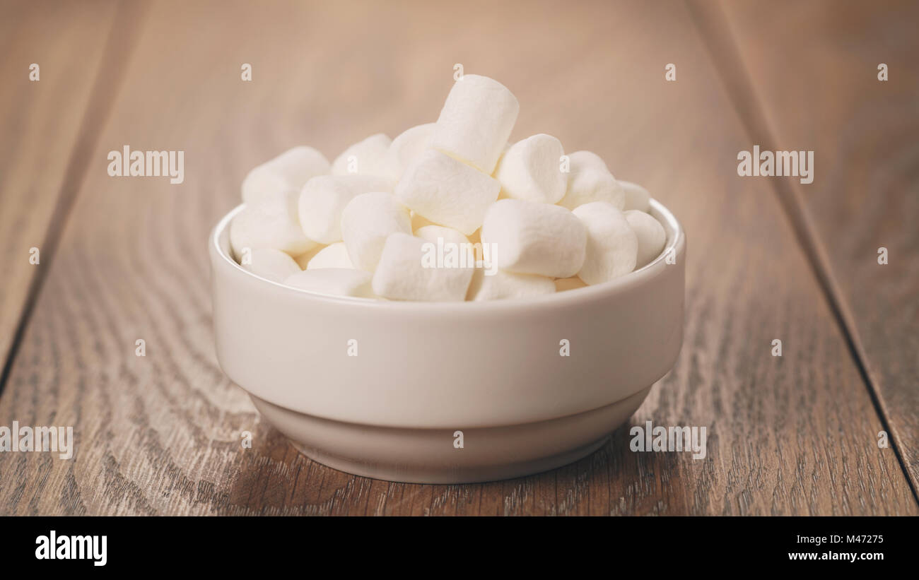 weiße Marshmallows in weiße Schüssel auf Tisch Stockfoto