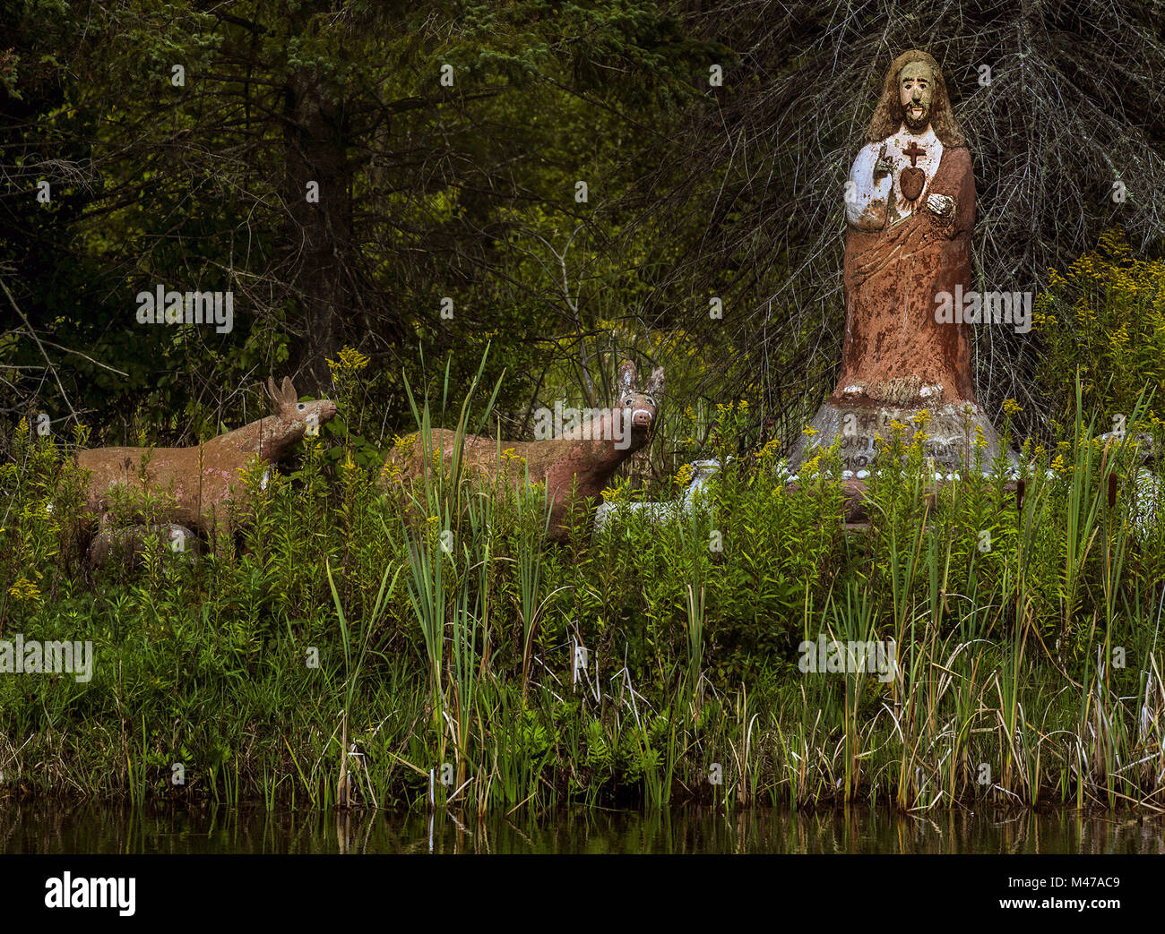 Lyons Falls, New York, USA. 24 Aug, 2015. Eine Statue von Jesus und ein paar Rehe Besucher Grüße über einem Teich an der Seite der Straße in der Nähe von Lyons Falls, New York. Credit: L.E. Baskow/ZUMA Draht/Alamy leben Nachrichten Stockfoto