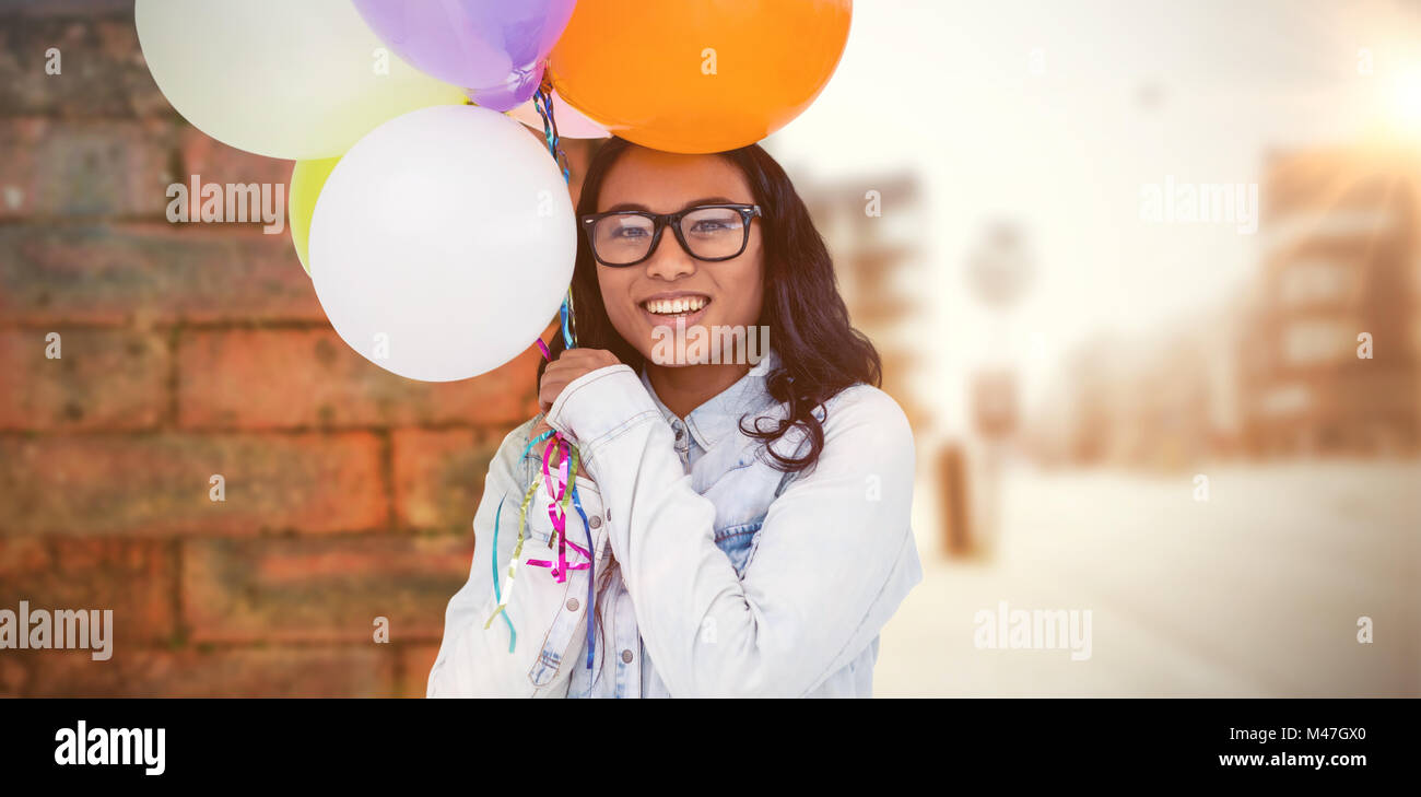 Zusammengesetztes Bild asiatische Frau mit bunten Luftballons Stockfoto