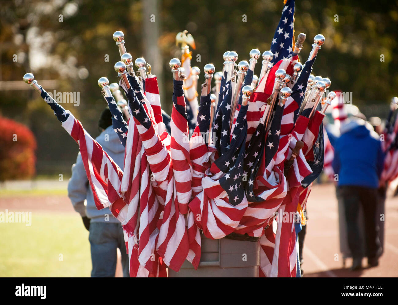Arbeitnehmer ziehen Fass voller bis rooled amerikanische Flaggen Stockfoto