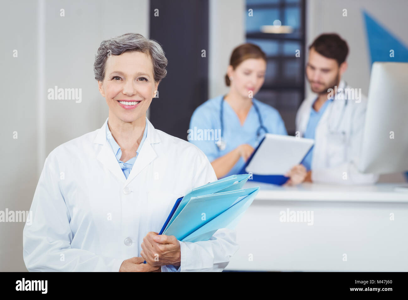 Porträt des Lächelns Ärztin Holding Arztberichte Stockfoto