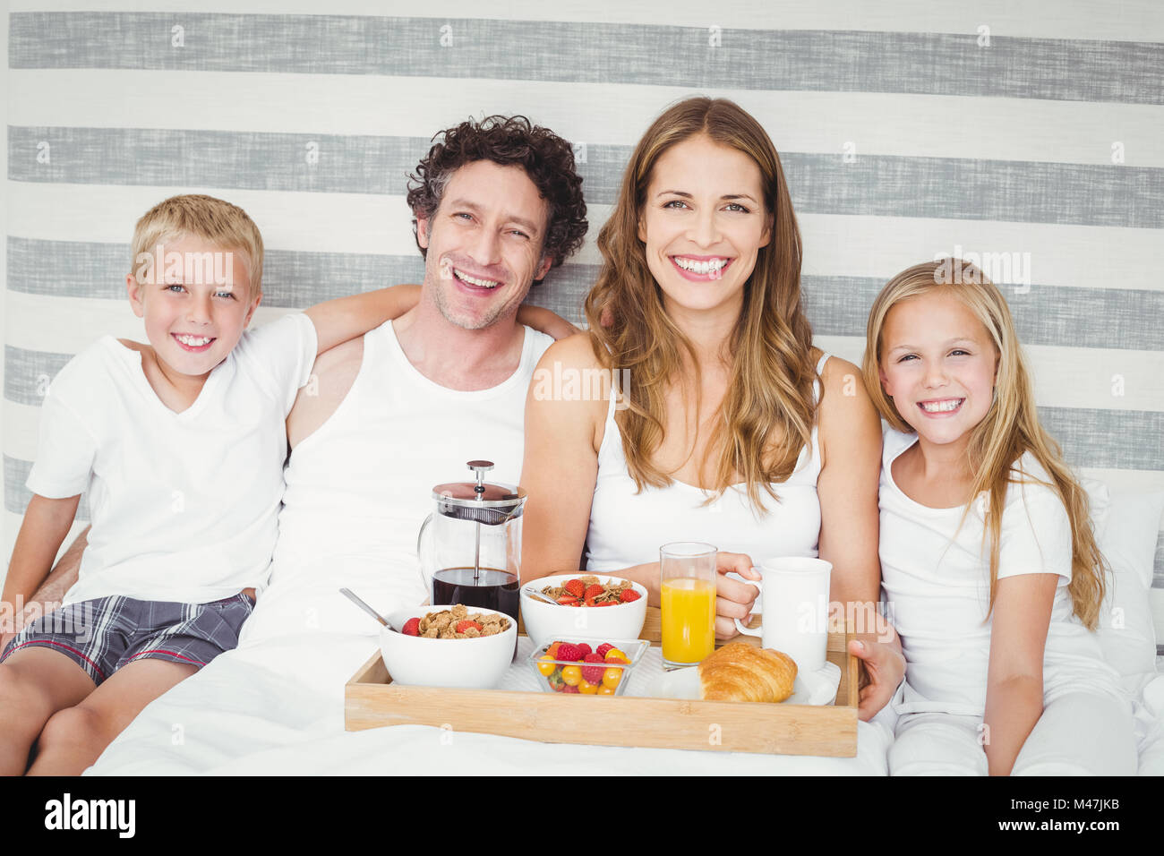 Porträt der glückliche Familie mit Frühstück am Bett Stockfoto