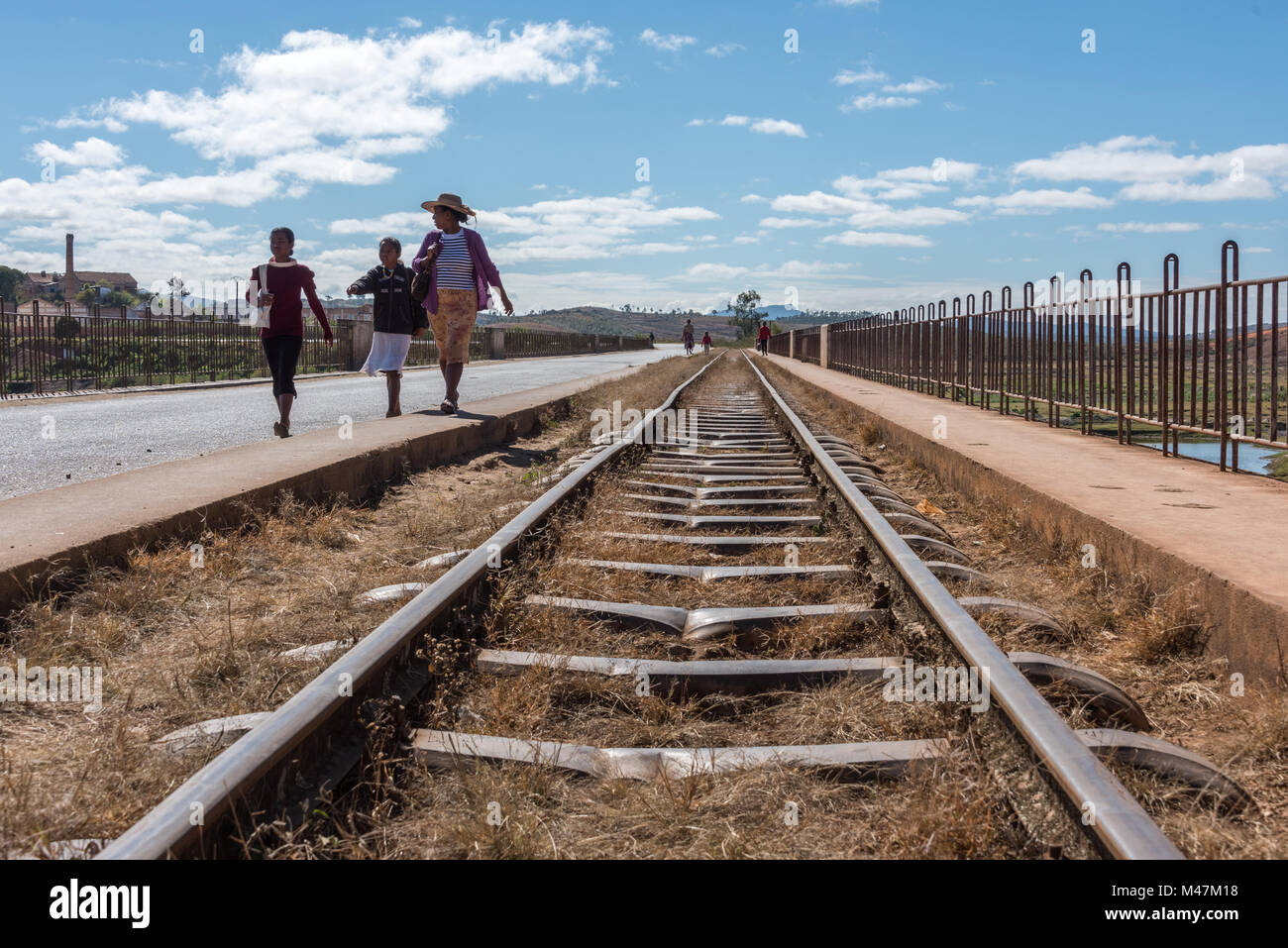 Menschen zu Fuß neben verbogen Eisenbahnlinie, Madagaskar Stockfoto