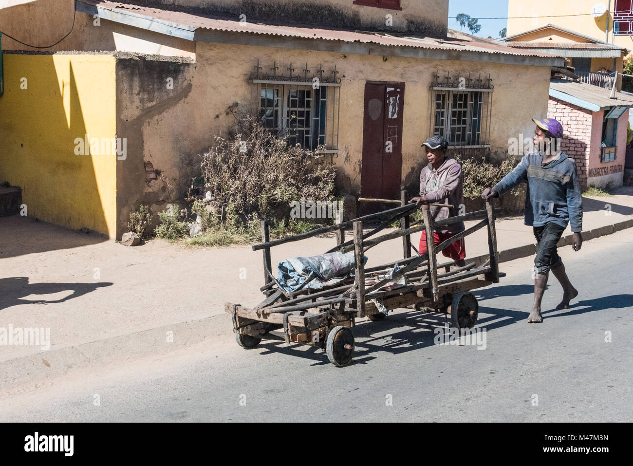 Menschen, die hölzerne Hand Warenkorb entlang der Straße, Madagaskar Stockfoto