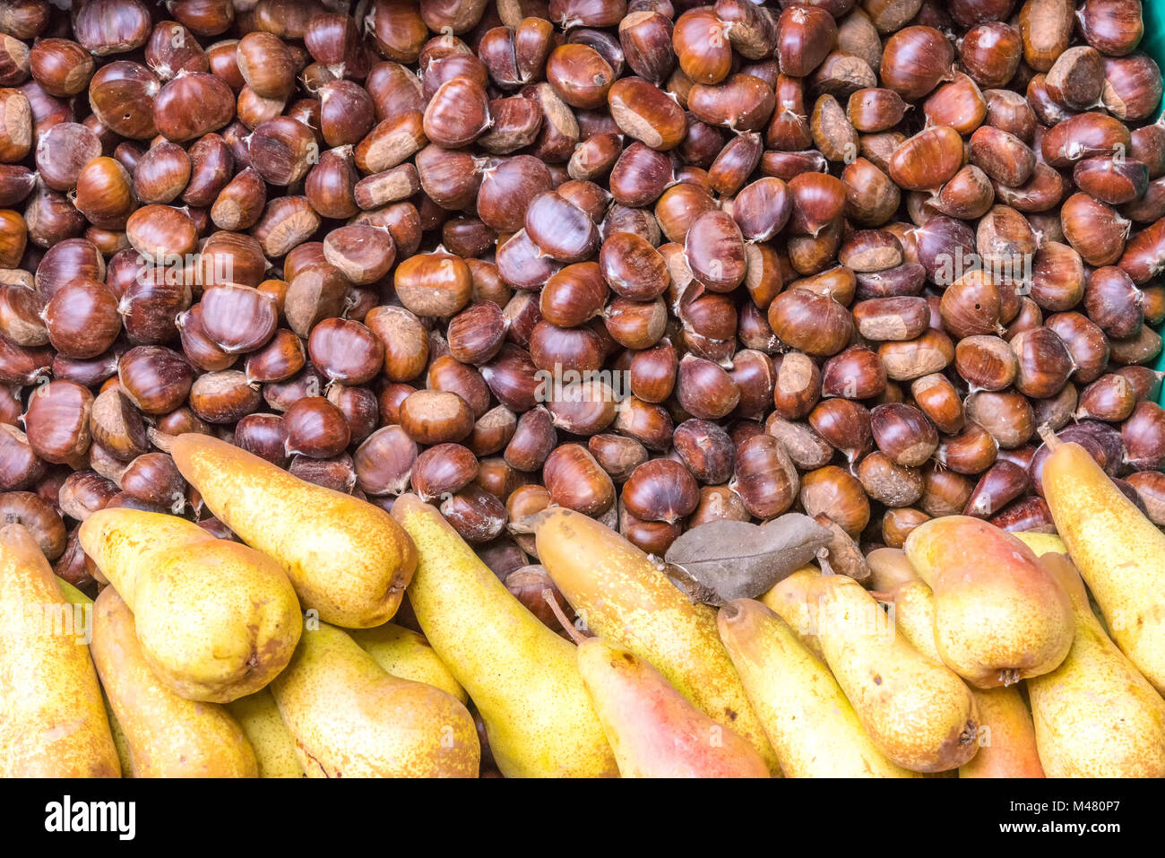 Braune Kastanien und gelben Birnen für Verkauf auf dem Markt Stockfoto
