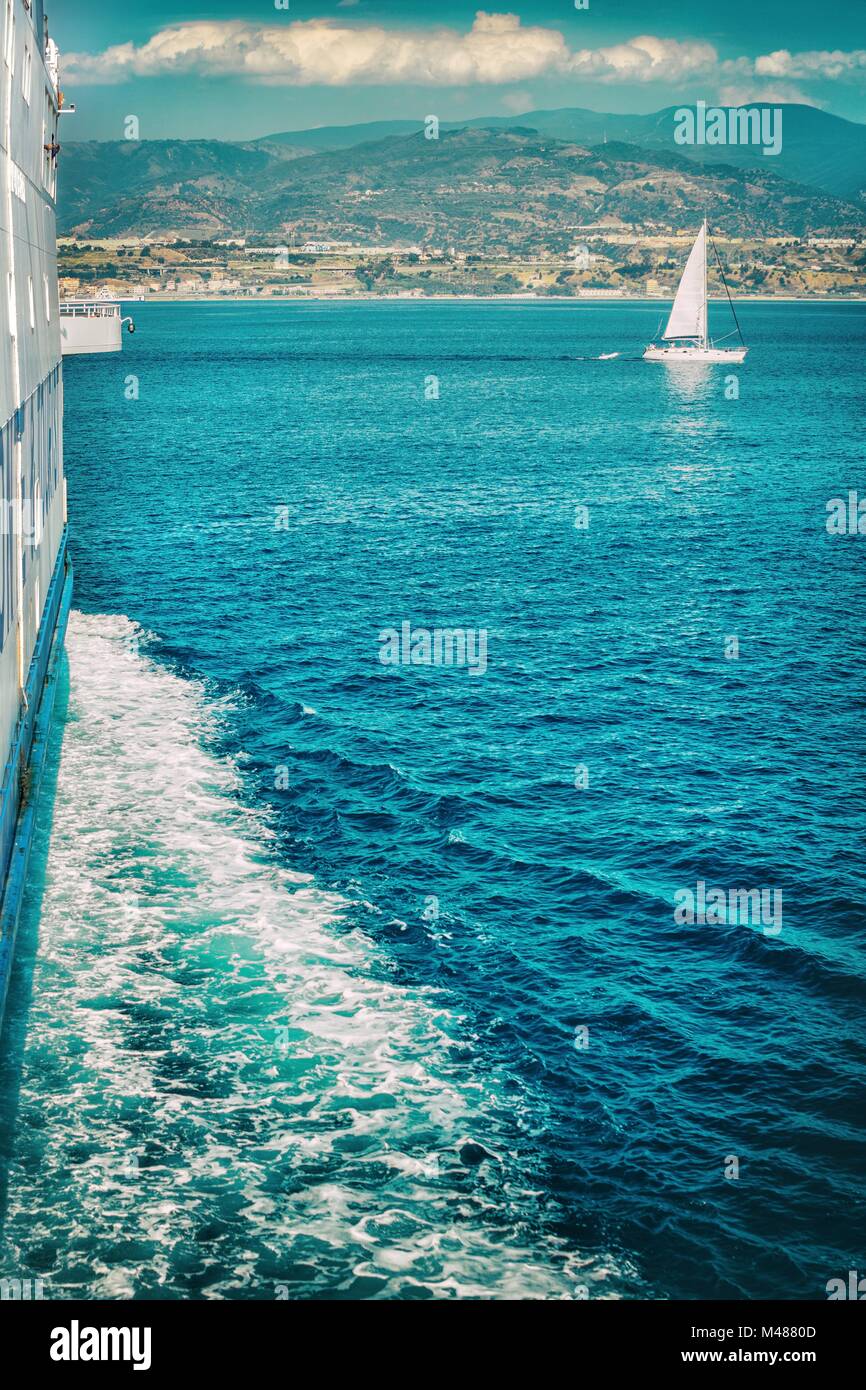 Schaumige Spur hinter des Schiffes mit Blick auf die Küste Stockfoto