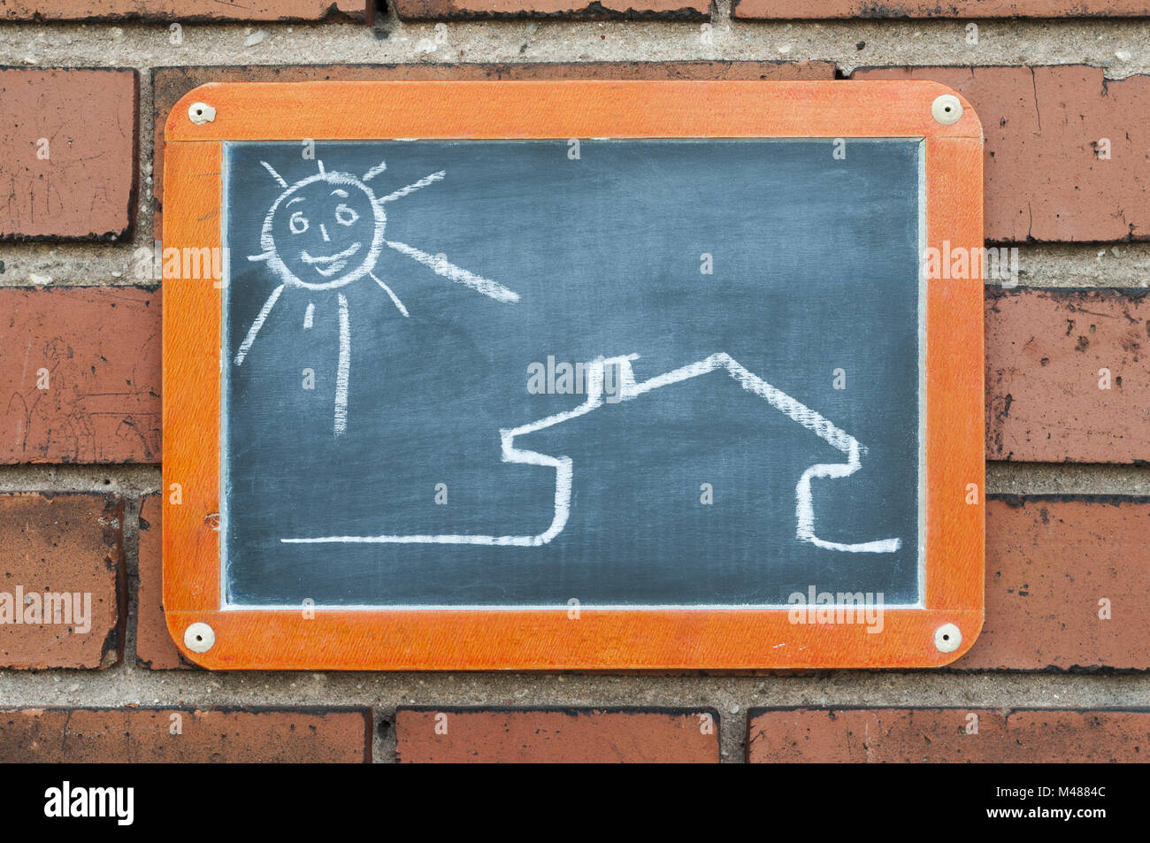 Board auf eine Mauer mit einem Haus und Sonne Stockfoto