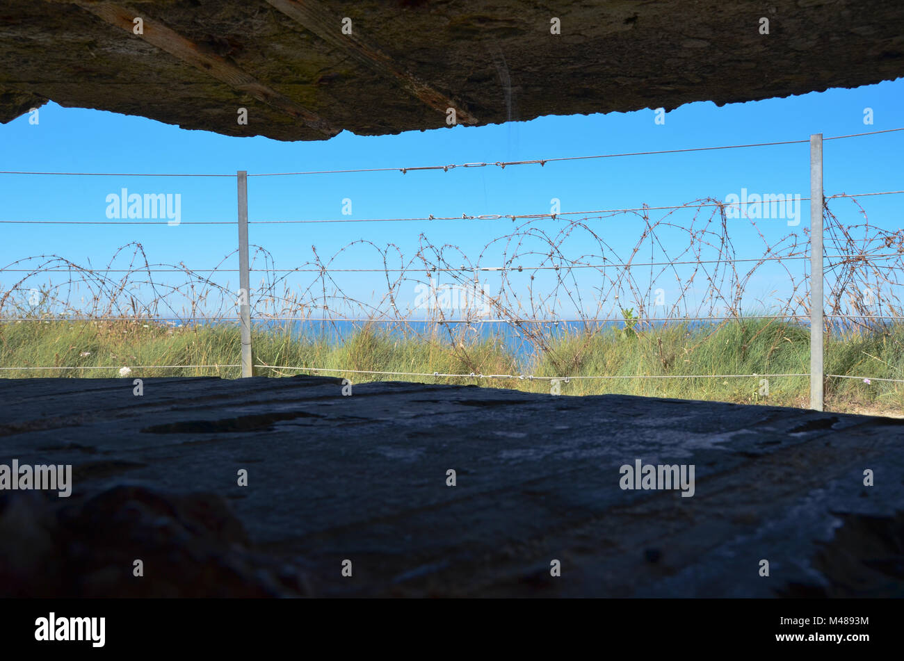 Mit Blick auf das Meer von der Innenseite der alten Welt Krieg 2 Klippe artilleriegeschützen Bunker oben Omaha Beach, Normandie, Frankreich - 17. Juli 2016. Keine Menschen. Stockfoto