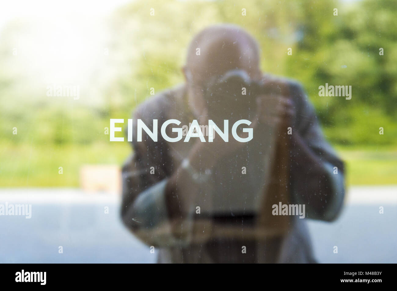 Fotograf hinter einer Glastür gekennzeichneten Eingang Stockfoto