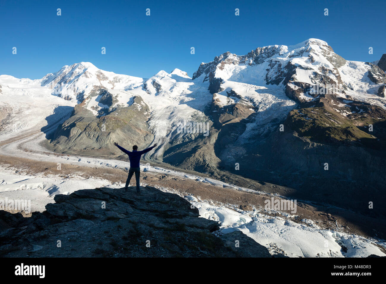 Wanderer silhouetted neben Gornergletscher und Monte Rosa, Gornergrat, Zermatt, Schweiz. Stockfoto