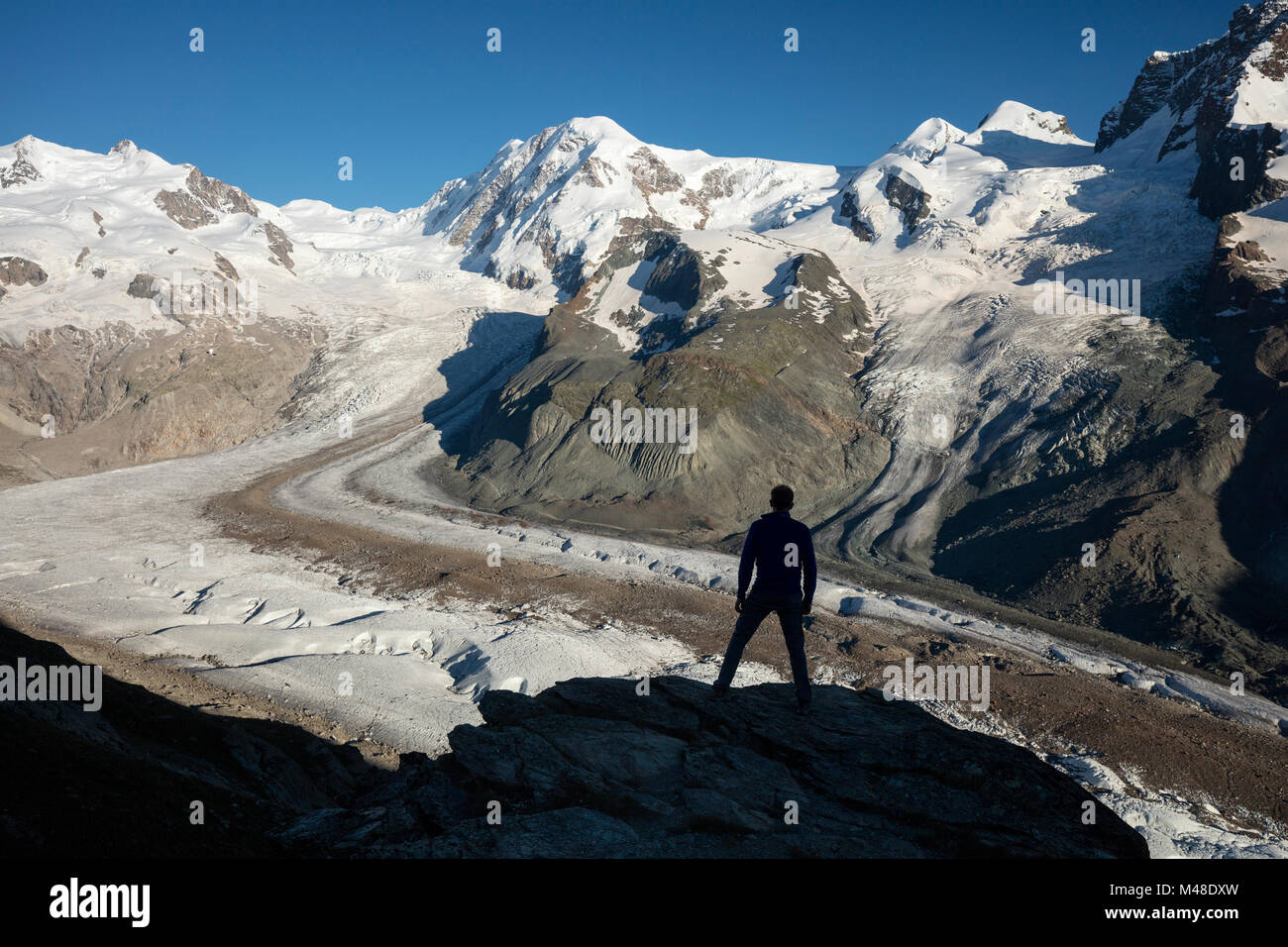 Wanderer silhouetted neben Gornergletscher und Monte Rosa, Gornergrat, Zermatt, Schweiz. Stockfoto