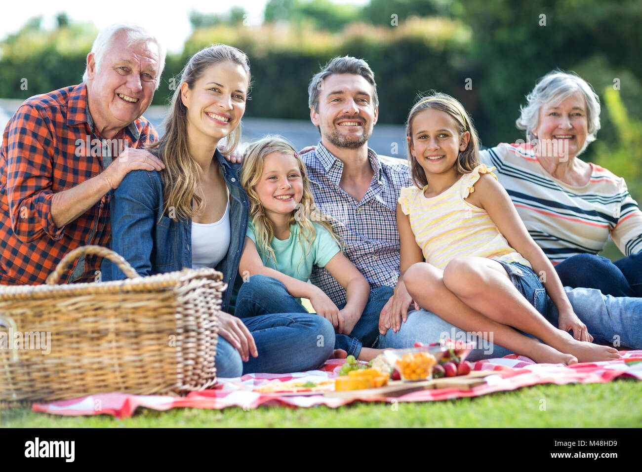 Glückliche mehr-Generationen-Familie sitzen auf Decke Stockfoto