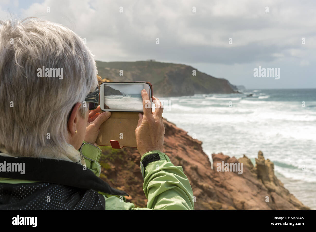 Ein älterer fotografiert mit einem Smartphone der Küste Stockfoto