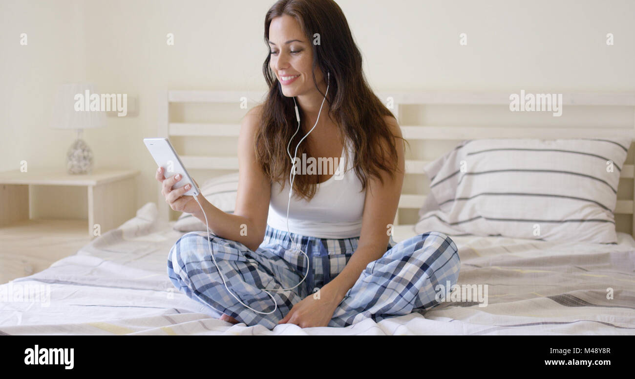 Lächelnde hübsche Frau Musikhören zu Hause Stockfoto