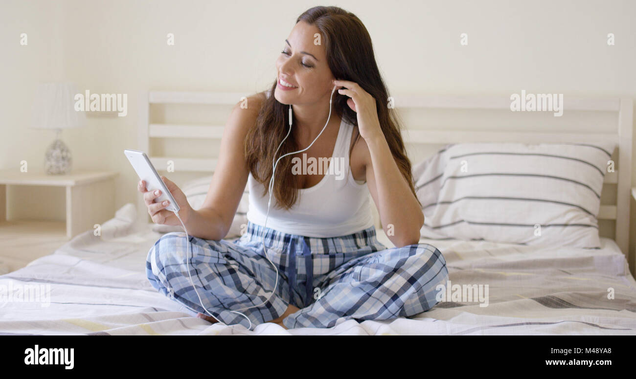 Lächelnde hübsche Frau Musikhören zu Hause Stockfoto