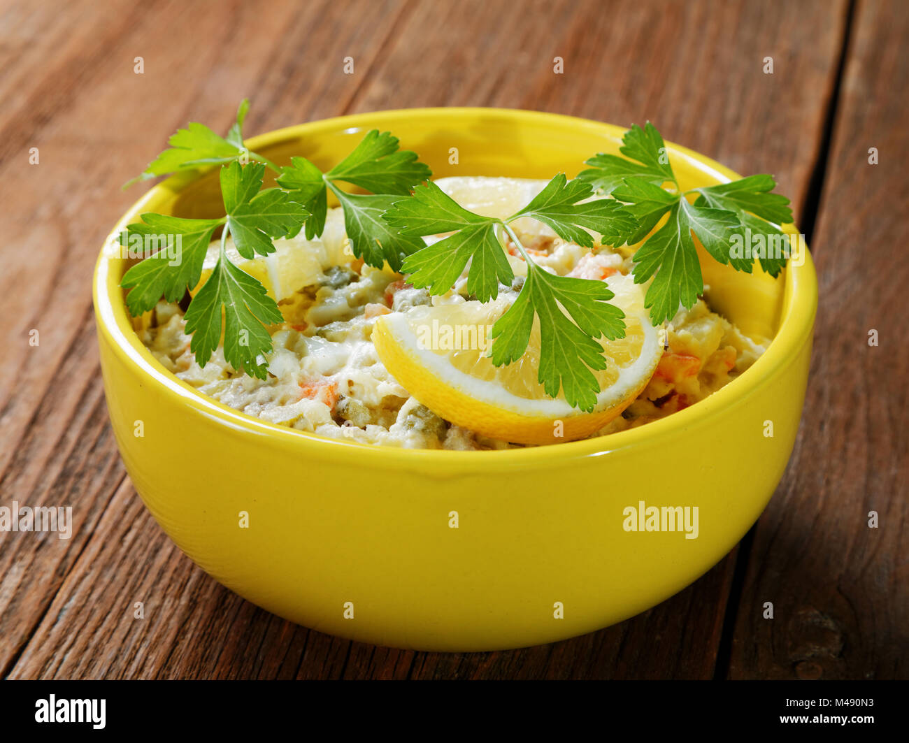 Schüssel Salat mit Zitrone und Petersilie auf rustikalen Tisch Stockfoto