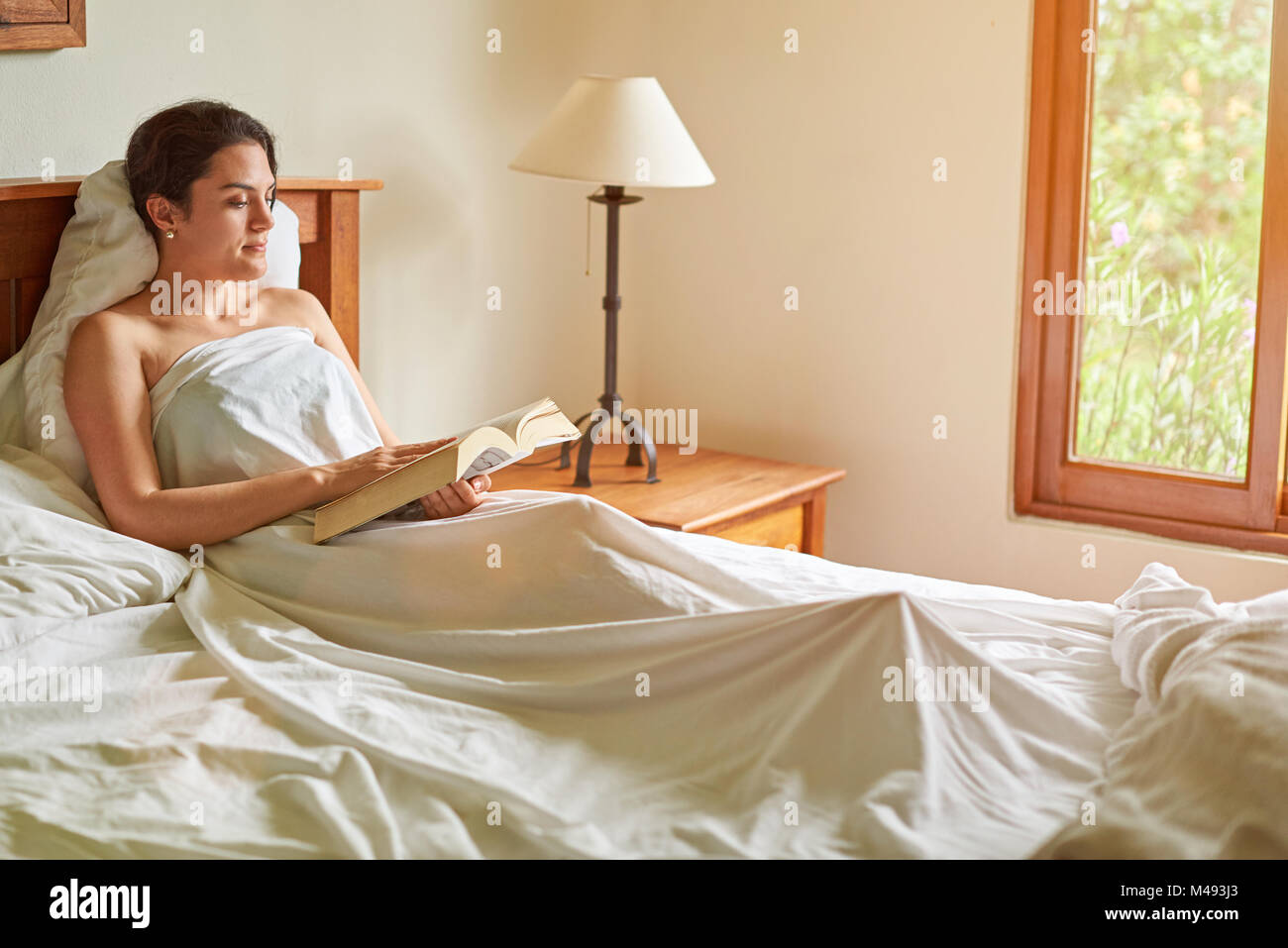 Frau mit Buch im Bett Zimmer. Lesen Buch Konzept Stockfoto