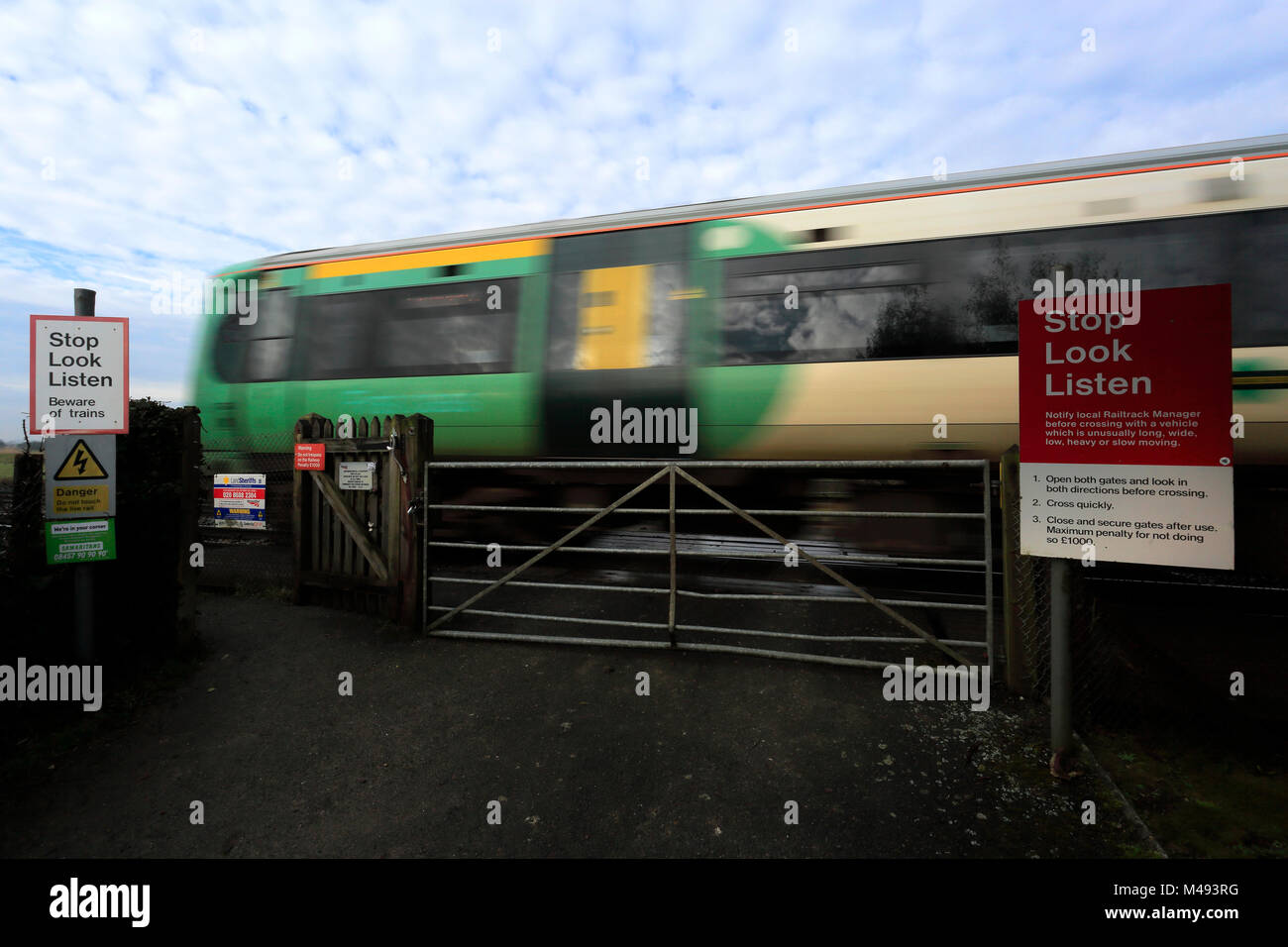 Southern Rail Zug vorbei an einem unbeschrankten Bahnübergang, Arundel, Sussex, England, Großbritannien Stockfoto