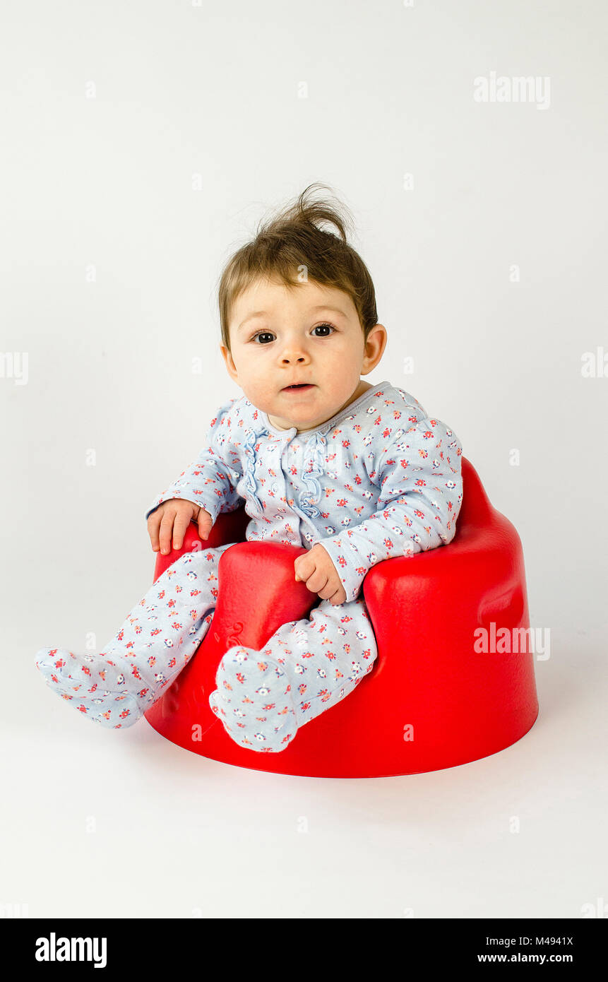 Cute Baby Mädchen in einem Kunststoff Sitz sitzt Stockfoto