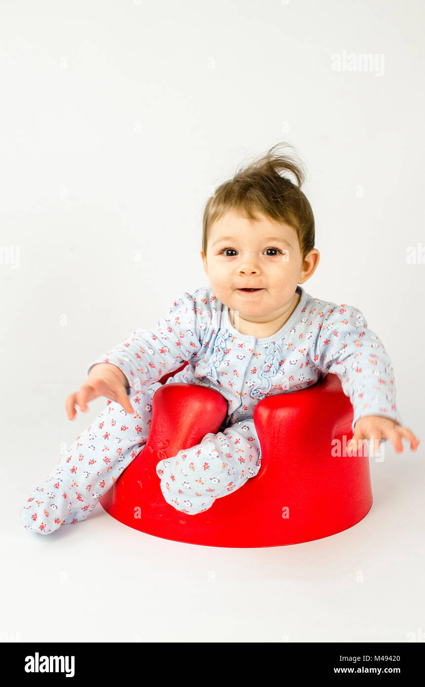 Cute Baby Mädchen in einem Kunststoff Sitz sitzt Stockfoto