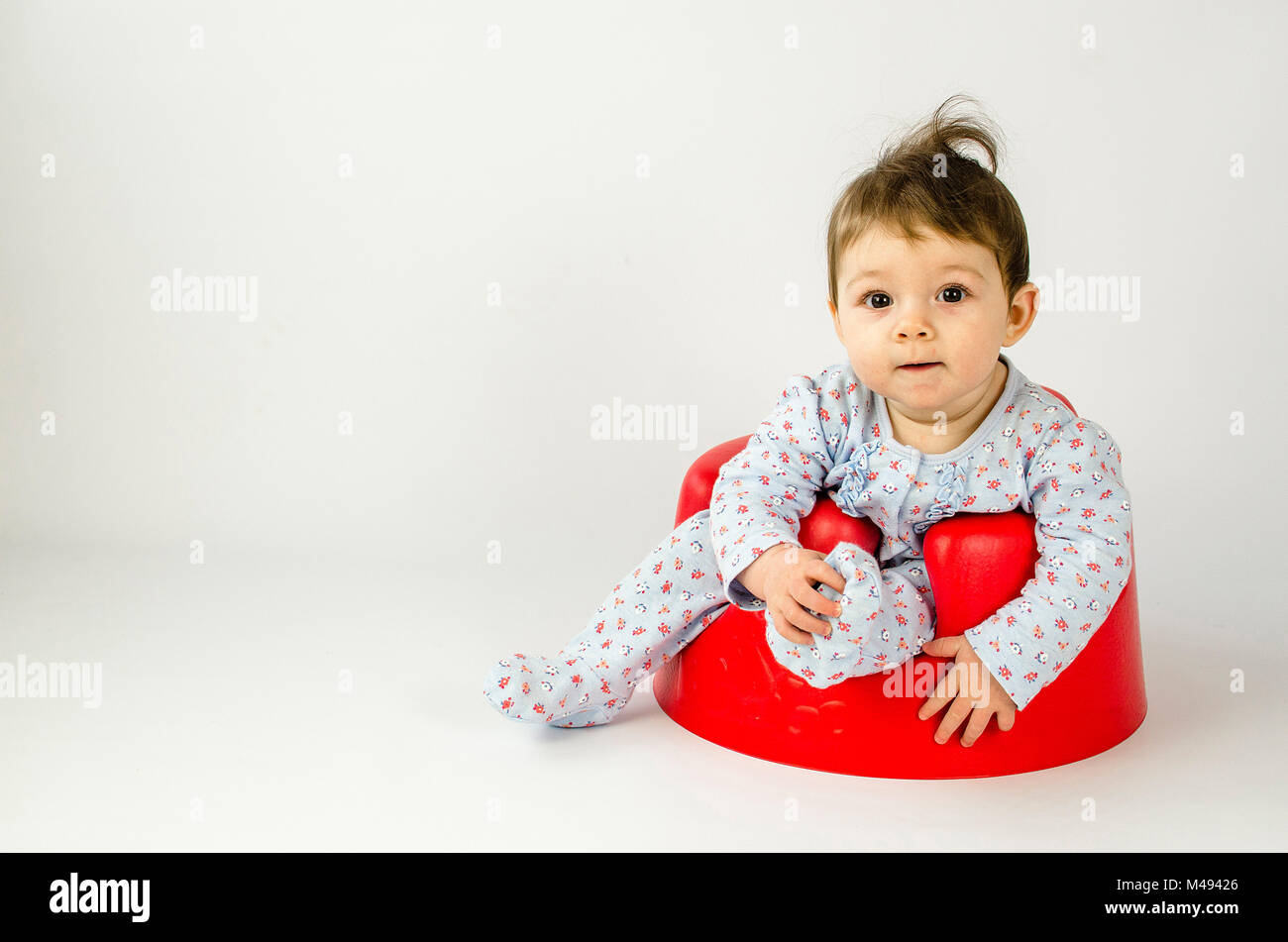 Cute Baby Mädchen in einem Kunststoff Sitz sitzt Stockfoto