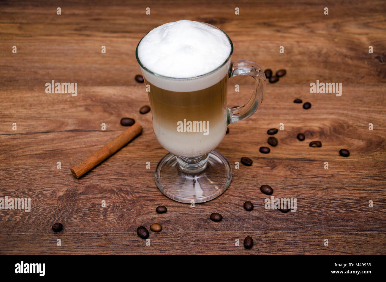 Heißes Getränk und Kaffee und Milch, Latte, Cappuccino, in einem schönen Glas Glas, auf einem Holztisch Stockfoto