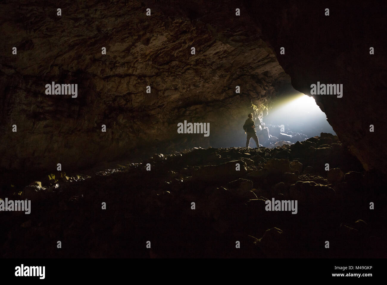 Höhlenforscher am Eingang der karstige Höhle in den Dinarischen Alpen, Slowenien. April 2016. Stockfoto