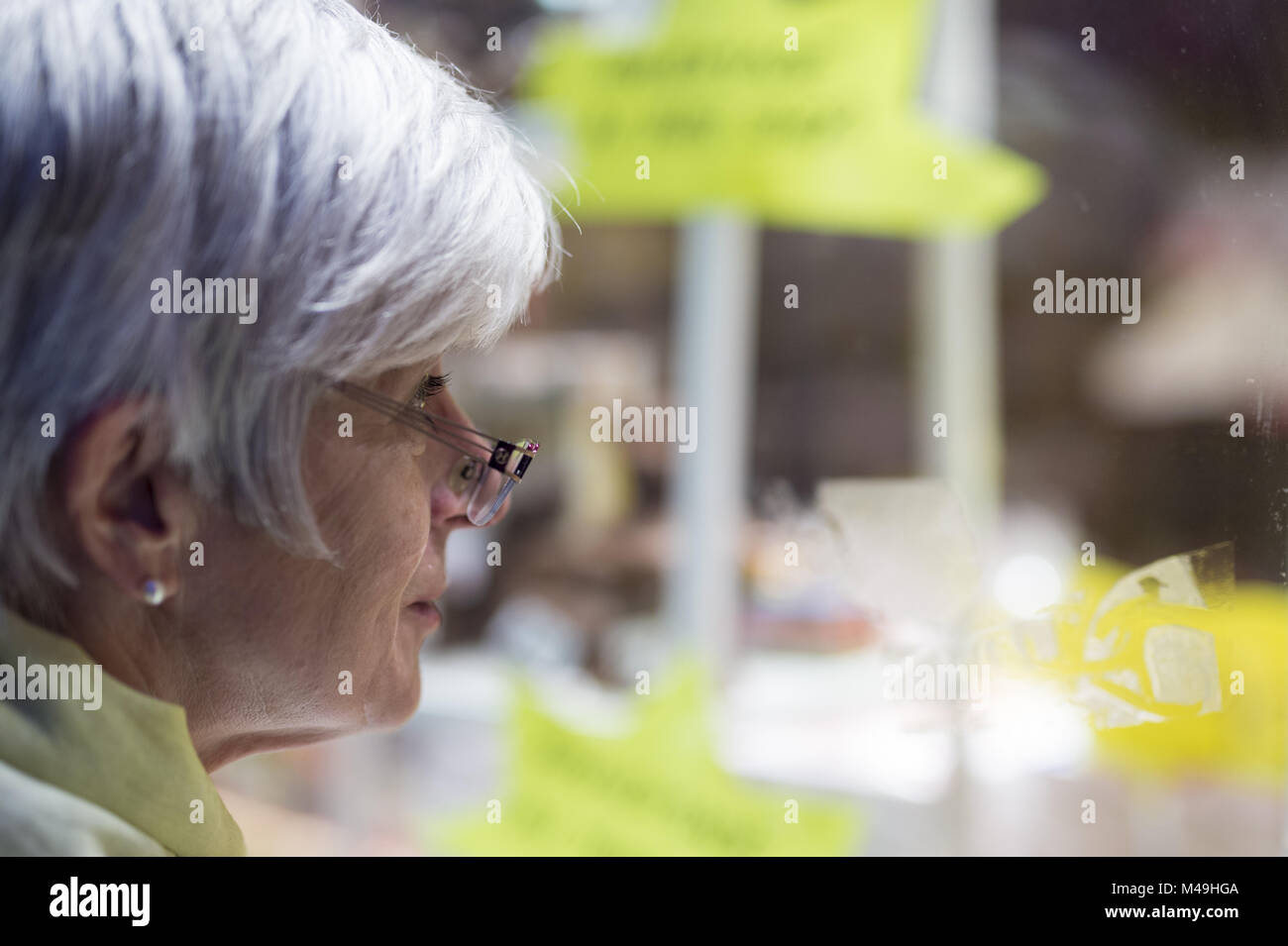 Ein älterer gesehen vergnügt Anzeige in einem Schaufenster. Stockfoto