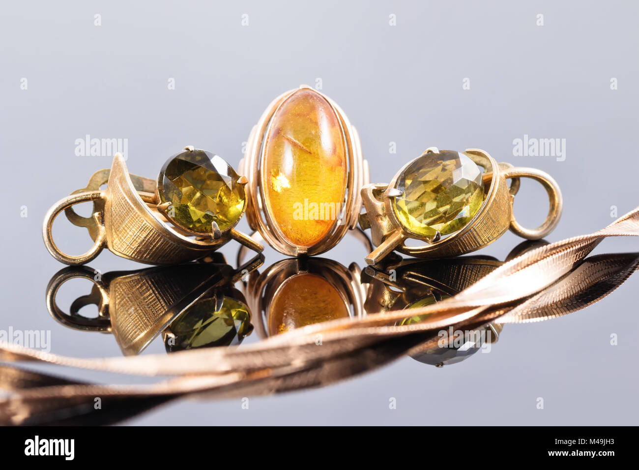 Gold Ring mit Bernstein und Ohrringe mit grünen Steinen Stockfoto