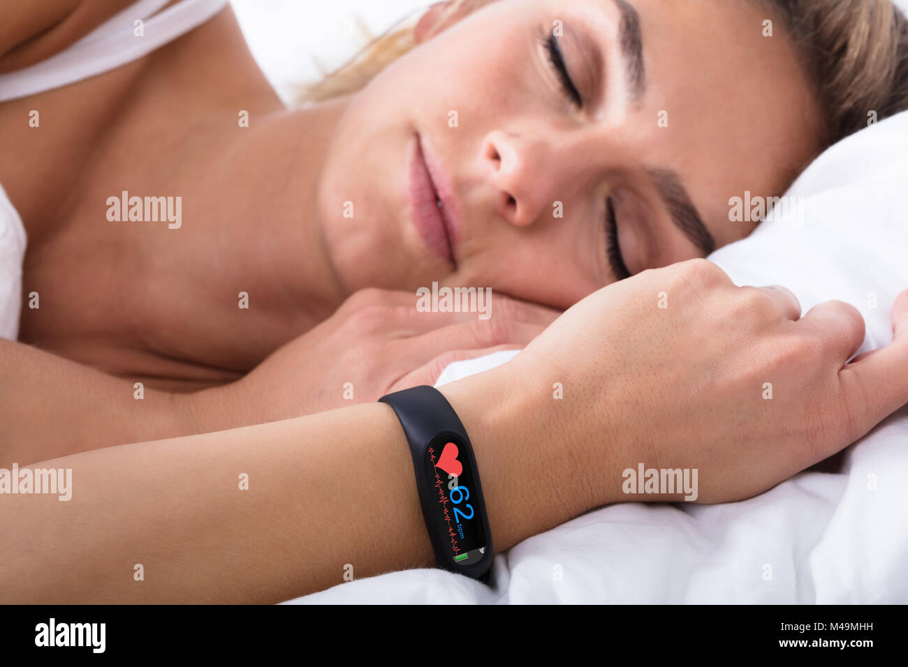 Fitness Tracker mit Heartbeat Rate auf Frau mit der Hand über das Bett Stockfoto