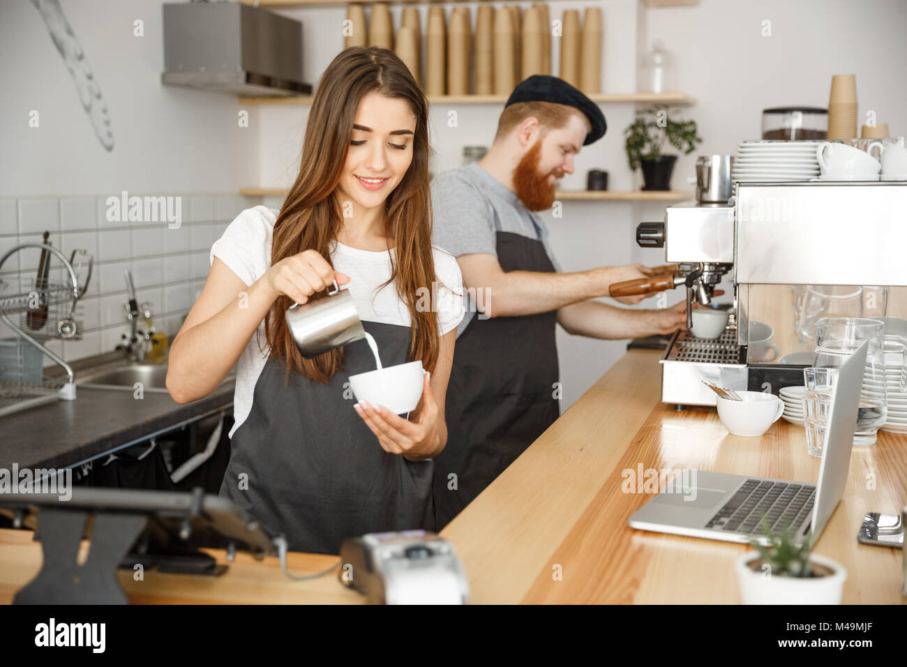 Kaffee Geschäftskonzept - close-up lady Barista im Vorfeld vorbereiten und Gießen Milch in die Tasse, während im Cafe. Stockfoto
