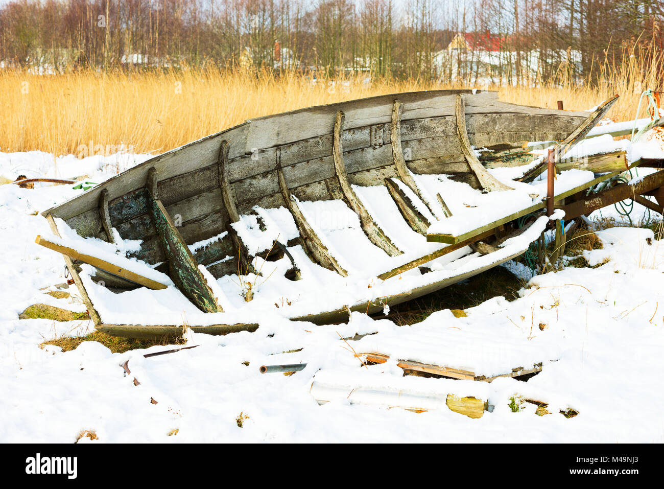 Alten hölzernen Ruderboot auf dem Land links und Drehen in Schutt im Winter Landschaft. Stockfoto