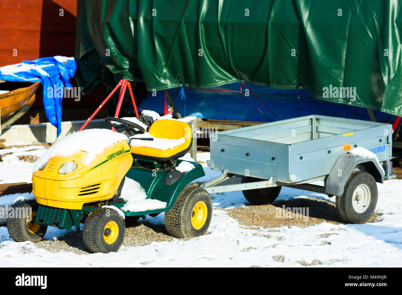 Saxemara, Schweden - Februar 7, 2018: Dokumentation des täglichen Lebens und der Umwelt. Kleine Yard-Man garten Traktor mit Anhänger im Schnee zu einem Mar abgedeckt Stockfoto Saxemara, Schweden - Februar 7, 2018: Dokumentation des täglichen Lebens und der Umwelt. Kleine Yard-Man garten Traktor mit Anhänger im Schnee zu einem Mar abgedeckt Stockfoto