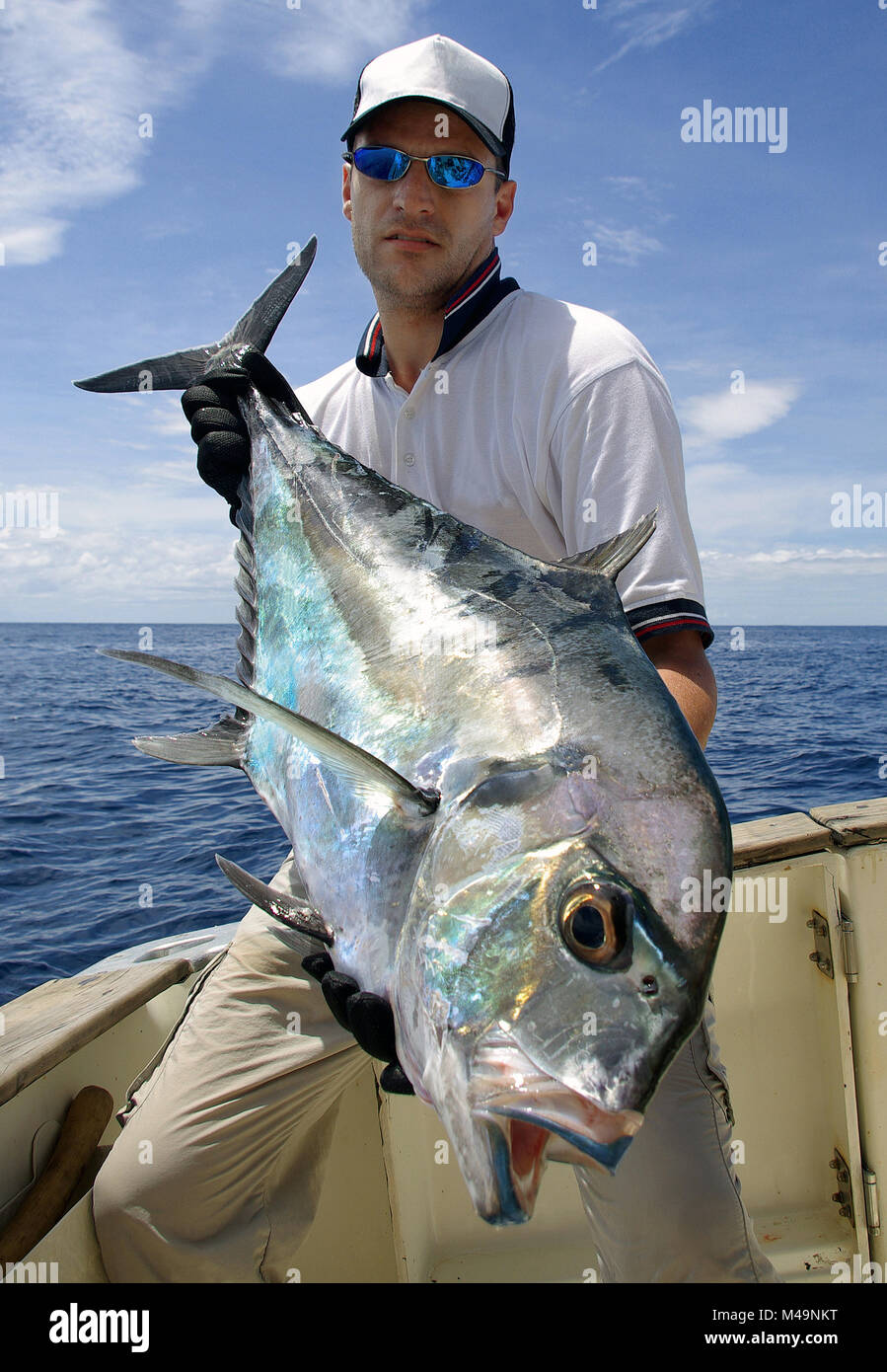 Hochseefischen - glückliche Fischer Holding ein Makrelen jack Stockfoto