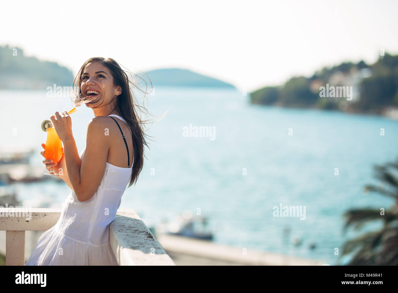 Unbeschwerte junge Frau auf Urlaub Sommer Urlaub Spaß an einem sonnigen Tag, entspannen mit Blick auf den Ozean, Wellen, genießen Sommer Stockfoto