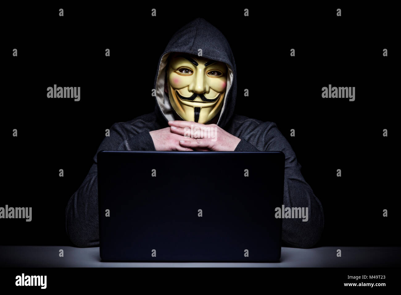 Mailand, Italien, Februar 2018: Hacker Verschleiß anonymus Maske mit Notebook im Dunkeln. Editorial Foto. Stockfoto