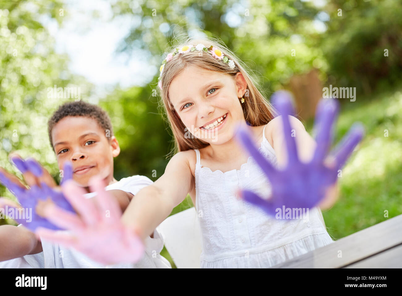 Kinder spielen, Malen mit Fingerfarben auf Geburtstagsparty im Garten Stockfoto