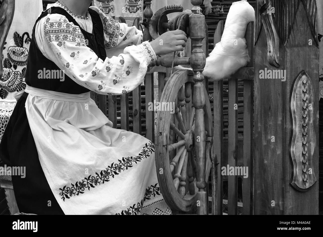Junge Frau spinnen Thread auf ein sich drehendes Rad. Schwarz-weiß-Foto. Stockfoto