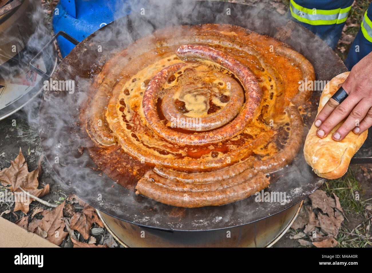 Ein Mann bereitet traditionell Würstchen draußen auf der Straße zu verkaufen. Stockfoto