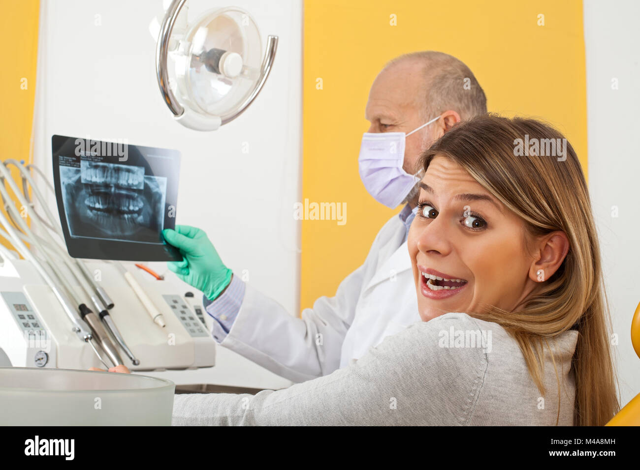 Nervöse junge weibliche Patienten an den Zahnarzt zu Dental X-ray mit Arzt suchen Stockfoto